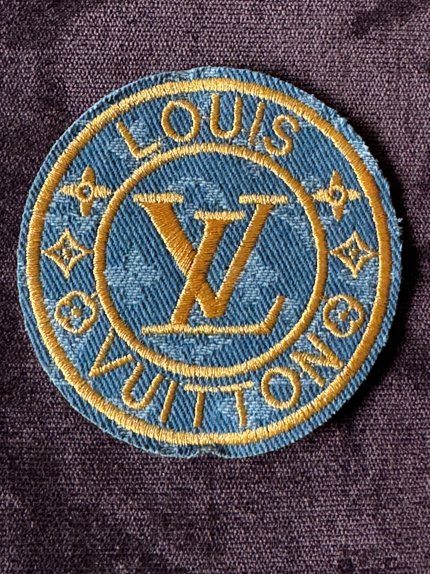 LV inspired embroidery circle patch, light denim material with writing in gold