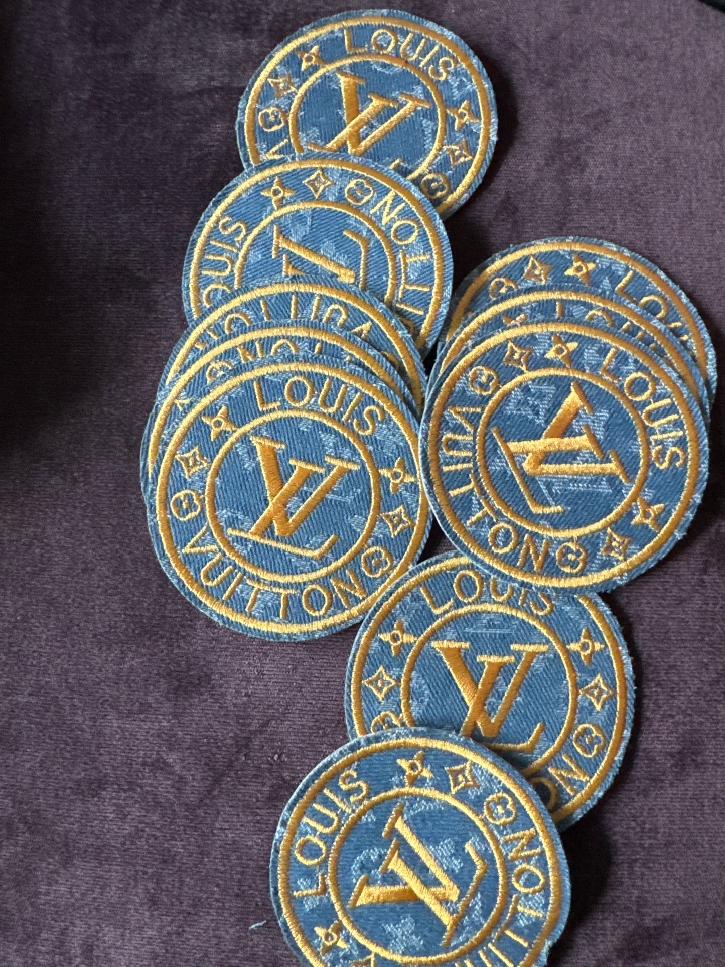 LV inspired embroidery circle patch, light denim material with writing in gold